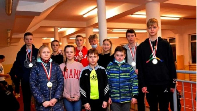 Zbiorowe zdjęcie złotych medalistów i uczestników zawodów w lekkoatletyce