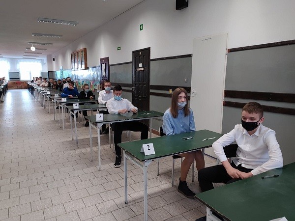 Uczniowie czekający w ławkach na próbny egzamin