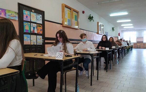 Uczniowie czekający w ławkach na próbny egzamin