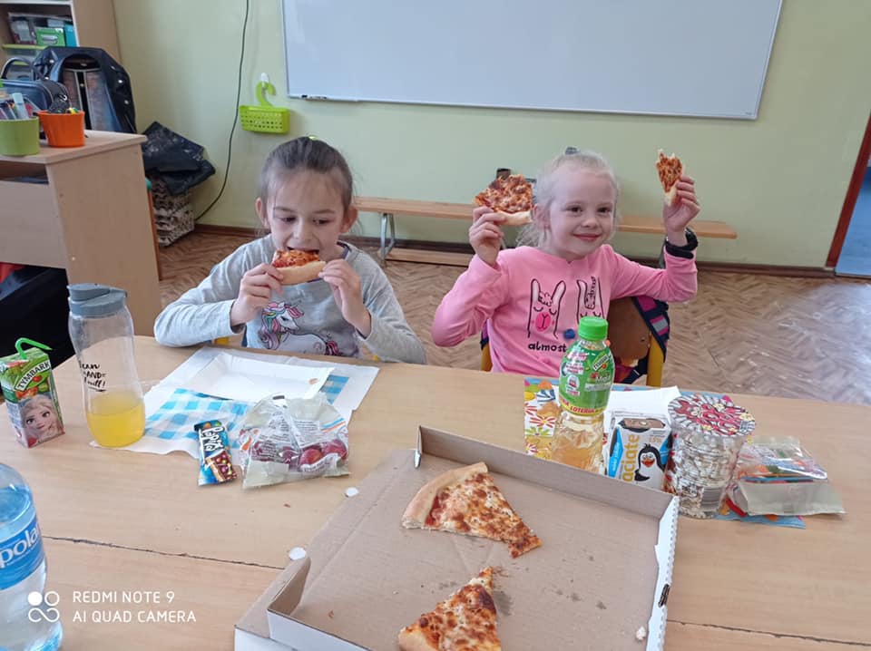 Dzieci w kinie, jedzący pizzę i grający w gry