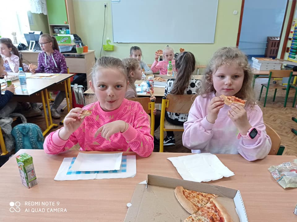 Dzieci w kinie, jedzący pizzę i grający w gry