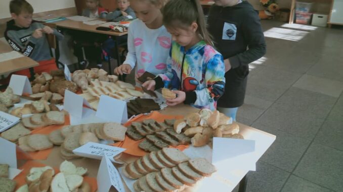 Dzieci podczas lekcji o rodzajach chleba i zawodach piekarza, młynarza.