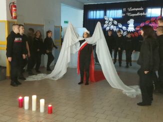 Uczniowie i nauczyciele podczas wystepu z okazji 11.11.