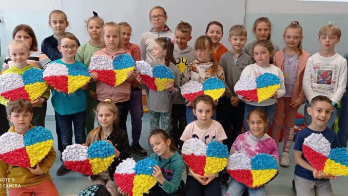 Dzieci z sercem złożonym z kolorów flag Polski i Ukrainy