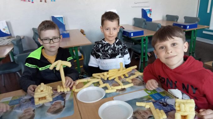 Uczniowie tworzą budowle z chrupek