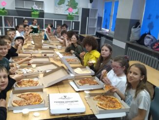 Uczniowie jedzą pizzę